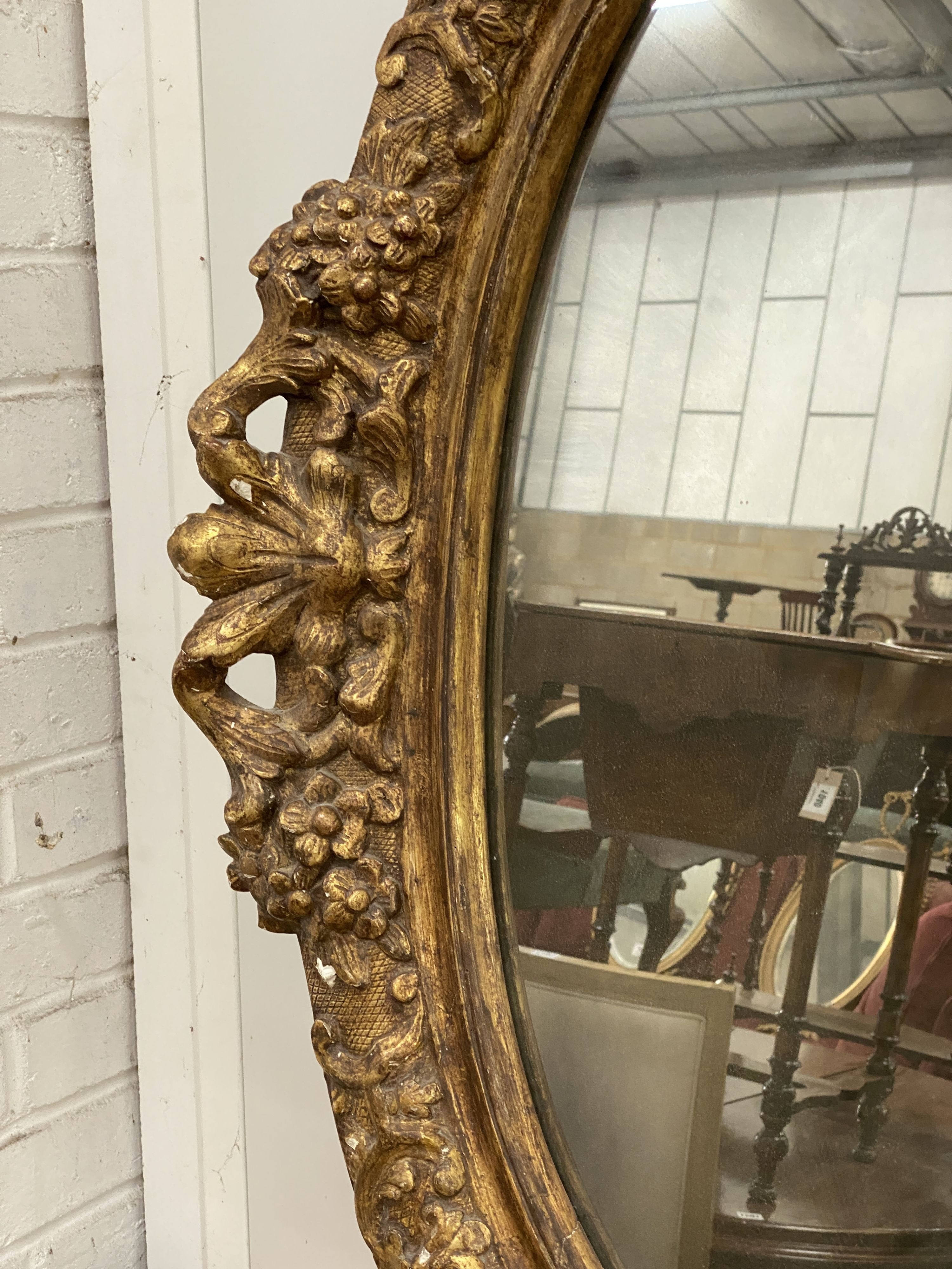 An oval giltwood and gesso wall mirror, width 89cm, height 108cm